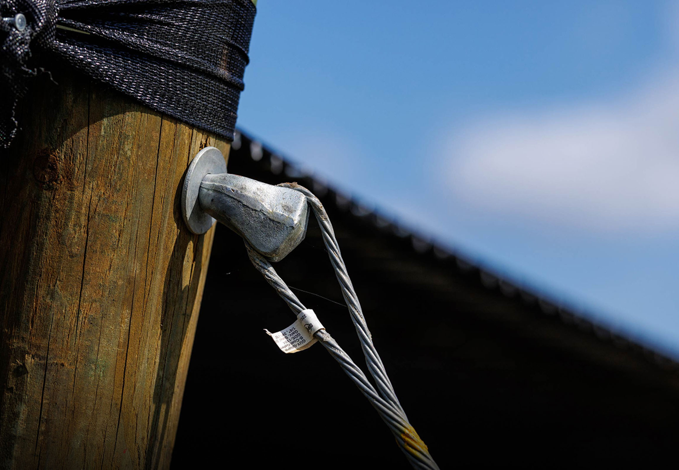 Close-up of galvanized cable and hardware securing shade structure post — durable building materials from Pierson Supply